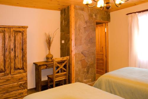 a bedroom with two beds and a desk with a chair at Confin Patagonico in El Chalten