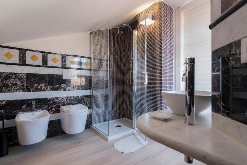 a bathroom with two sinks and a toilet and a shower at Merlo d'Oro in Carrara