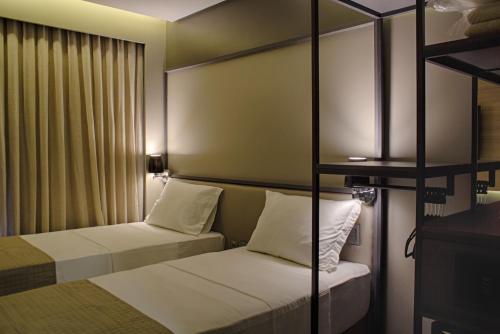 two beds in a room with two bunk beds at Slaviero Campina Grande in Campina Grande