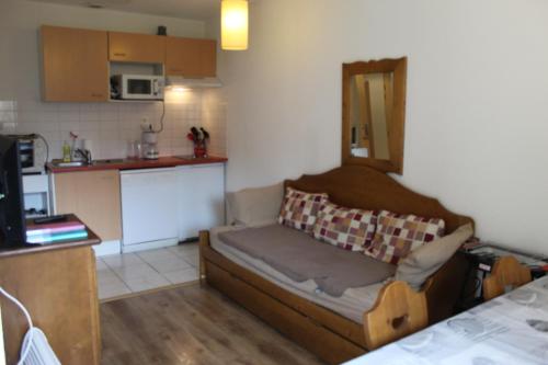 Una sala de estar con un sofá y una cocina. en Appartement Nolhan, en Cauterets
