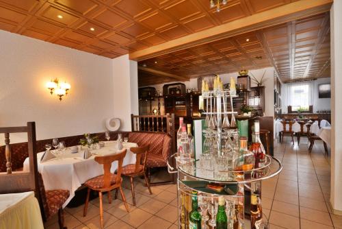 a restaurant with tables and chairs and bottles at Landgasthof & Hotel KRONE Eischleben in Ichtershausen