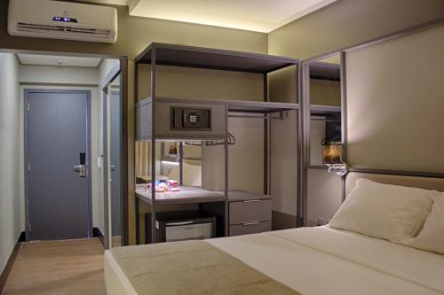a bedroom with a bed and a desk in it at Slaviero Campina Grande in Campina Grande