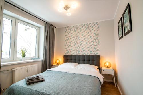 sypialnia z dużym łóżkiem i 2 oknami w obiekcie LEŚNA#24 w Olsztynie