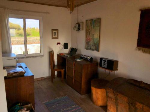a room with a desk with a computer and a window at Casa da Paz in Cedros