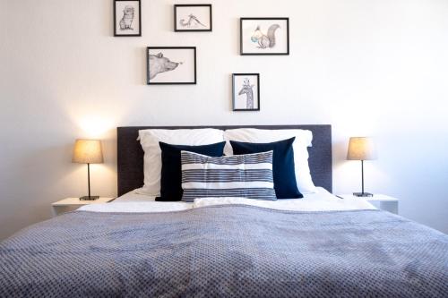 een slaapkamer met een bed met vier foto's aan de muur bij Helles Design-Appartement an der Messe in Essen