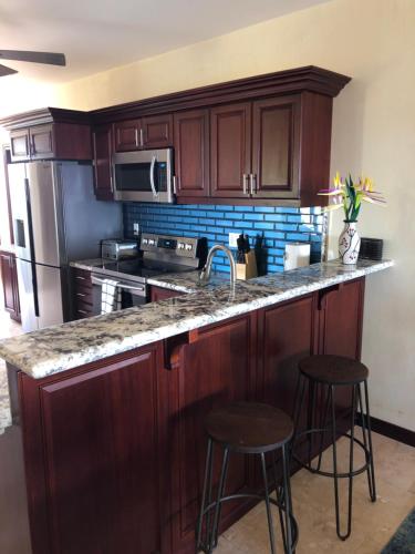 a kitchen with wooden cabinets and a counter with stools at The Meridian at Lighthouse Point in West Bay