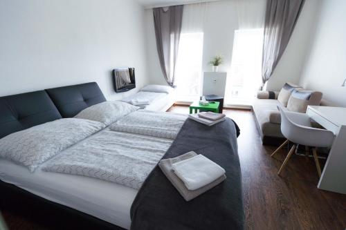 a bedroom with a large bed and a couch at Haas Apartments Downtown with Parking in Brno