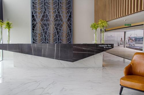 a lobby with a reception desk and a chair at Slaviero Campina Grande in Campina Grande