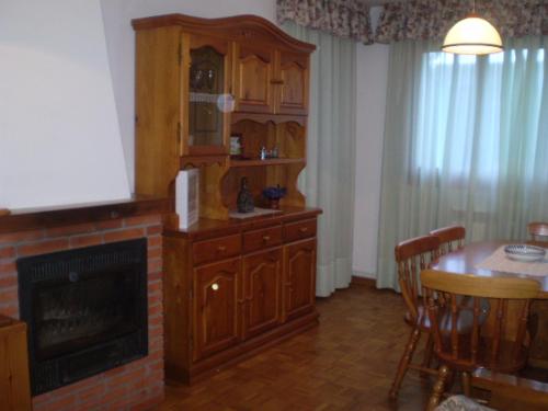 a living room with a fireplace and a dining table at Apartamento Maladeta in Torla