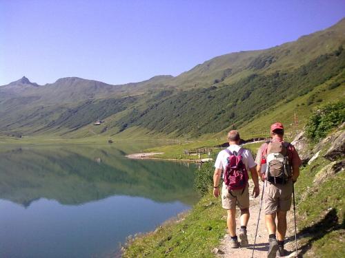 two men walking down a trail next to a lake at Salzburger Stubn in Kleinarl