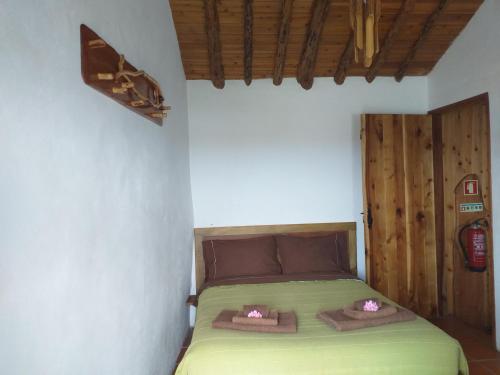 Habitación pequeña con cama verde y puerta de madera. en Casa da Fajã - RRAL nº 635 en Fajã da Caldeira de Santo Cristo