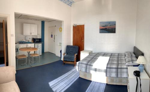 a bedroom with a bed and a table and a kitchen at Beeton Villas Holiday Apartments in Blackpool