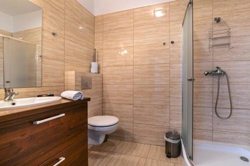 a bathroom with a shower and a toilet and a sink at Villa 4 Pory Roku in Jastrzębia Góra