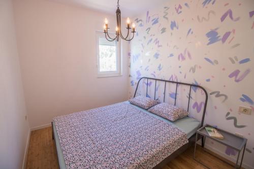 ein Schlafzimmer mit einem Bett und einer Wand mit lila Schmetterlingen in der Unterkunft Mary in Omiš