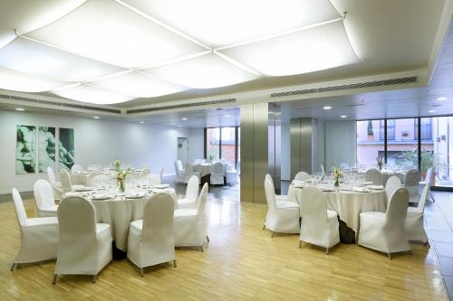 a banquet hall with white tables and white chairs at Exe Tres Cantos in Tres Cantos