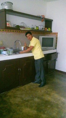 a man standing at a sink in a kitchen at La casa del nenufar in Oaxaca City