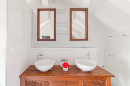 a bathroom with two sinks and two mirrors at CAZA TURQUOIZ in Rivière-Salée