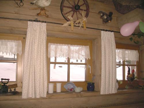 a room with two windows with white curtains at Dorf Alm in Obergurgl