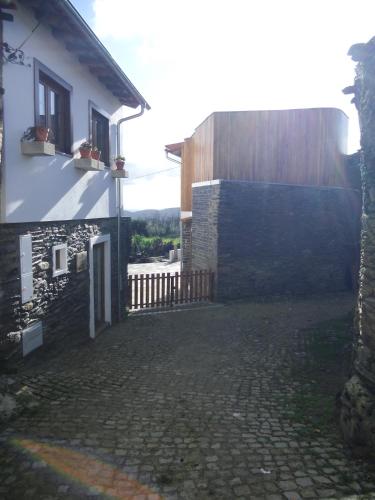 a white building with a gate and a fence at Casas de Campo Podence in Macedo de Cavaleiros