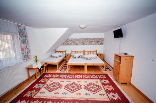 a living room with two tables and a rug at Pensiunea Soare si Luna in Praid