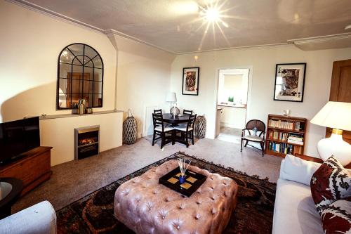 a living room with a couch and a table at Butler's Apartment. Flat 5, Dalmore House, Helensburgh, Scotland G84 8JP in Helensburgh