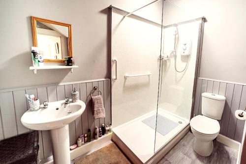 La salle de bains est pourvue d'une douche, d'un lavabo et de toilettes. dans l'établissement Butler's Apartment. Flat 5, Dalmore House, Helensburgh, Scotland G84 8JP, à Helensburgh
