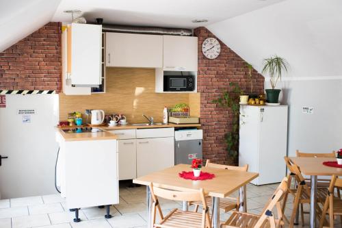 a kitchen with white cabinets and a brick wall at Hotelik Okęcie 39 - Nocleg i Parking Blisko Lotnisko Okęcie in Warsaw