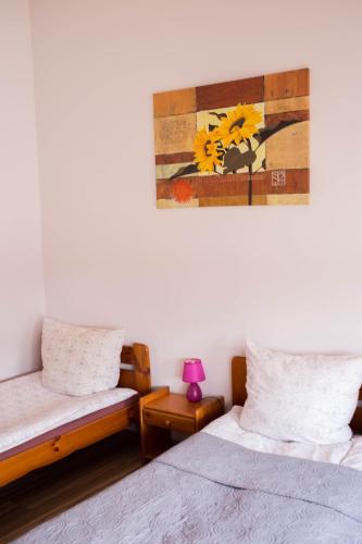a bedroom with two beds and a painting on the wall at Hotelik Okęcie 39 - Nocleg i Parking Blisko Lotnisko Okęcie in Warsaw
