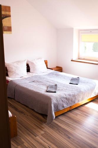 a bedroom with a large bed with two towels on it at Hotelik Okęcie 39 - Nocleg i Parking Blisko Lotnisko Okęcie in Warsaw