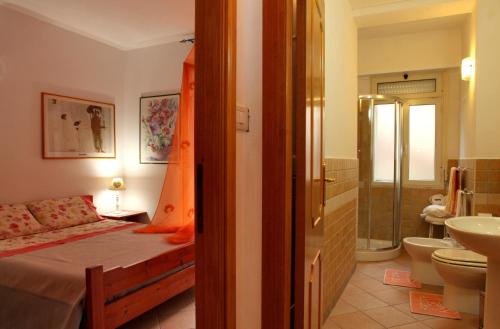 a bedroom with a bed and a bathroom at Casa Pireddu in Cala Gonone