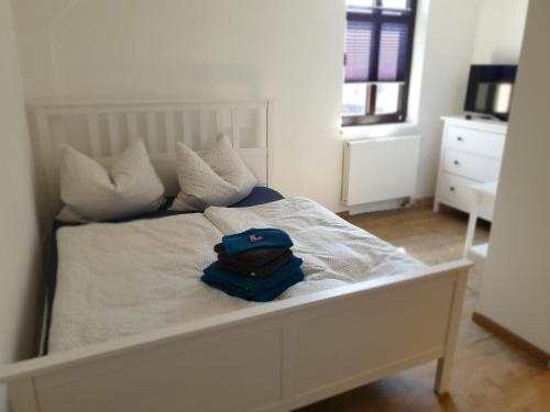 Una cama blanca con un sombrero azul. en Turmklause, en Luckenwalde