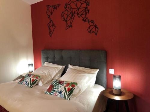 a bedroom with a white bed with a red wall at L Esprit du Clain chambres d hôtes BandB de standing proches du Futuroscope Golf et Lac de St Cyr in Naintré
