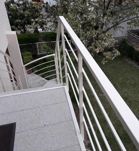 a white railing on the stairs of a house at Villa Domina in Gevgelija