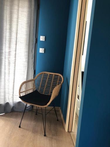 a chair sitting in a room with a blue wall at L Esprit du Clain chambres d hôtes BandB de standing proches du Futuroscope Golf et Lac de St Cyr in Naintré