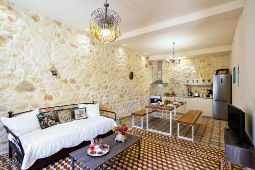 a living room with a white couch and a kitchen at Michalis Stonehouse in Chania Town