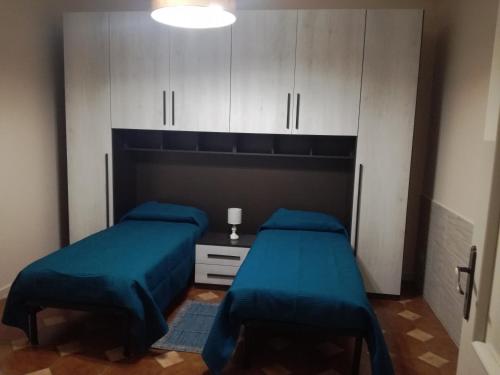 1 Schlafzimmer mit 2 Betten und weißen Schränken in der Unterkunft Casa vacanza Petrulli in Zafferana Etnea