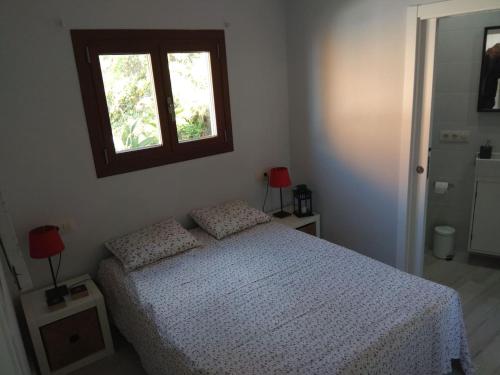 um quarto com uma cama com uma janela por cima em A Guaira, fantástico apartamento al borde del mar em Oia