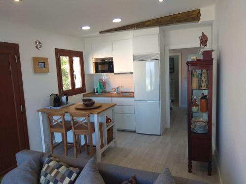 オイアにあるA Guaira, fantástico apartamento al borde del marのキッチン(ソファ、テーブル、冷蔵庫付)