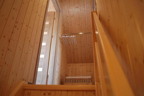 an empty shower in a wooden room with a mirror at Żurawie domki letniskowe in Kopalino