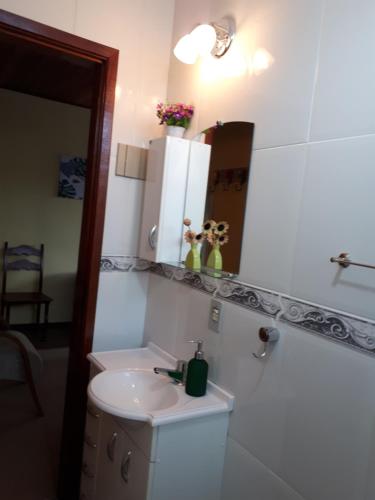 a bathroom with a sink and a mirror at Suíte com vista da Serra in Teresópolis