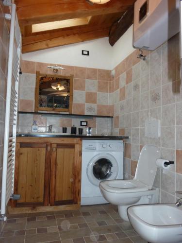 a bathroom with a toilet and a washing machine at La Cincia in Morgex