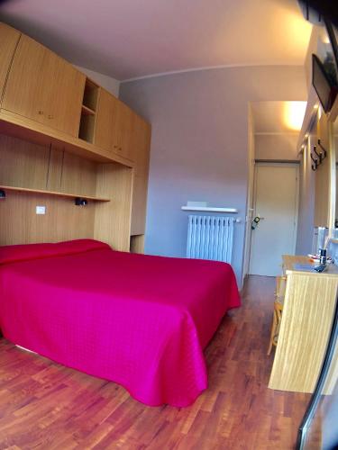 a bedroom with a large bed with a red blanket at Hotel La Bussola in Padenghe sul Garda