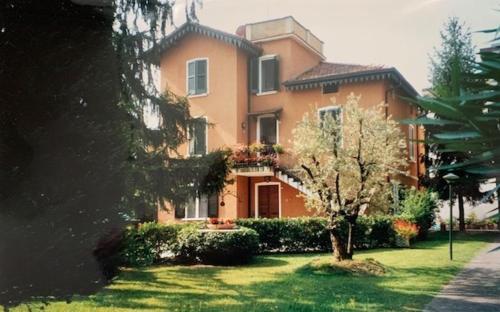 デセンツァーノ・デル・ガルダにあるAppartamento Villa Margheritaの庭の木のある大きなオレンジの家