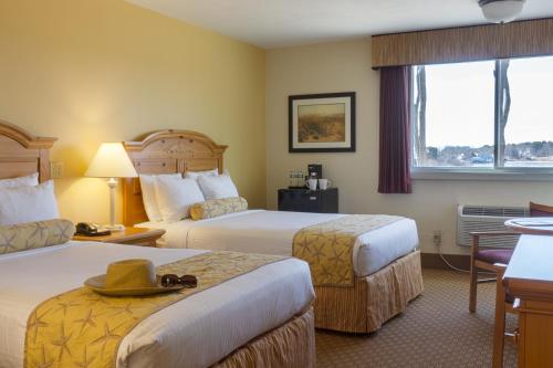 a hotel room with two beds and a window at Bayside Resort Hotel in West Yarmouth