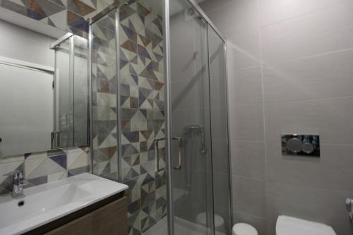 ラゴスにあるUrban art Lagosのバスルーム(ガラス張りのシャワー、シンク付)