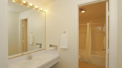 a white bathroom with a sink and a mirror at Winners Inn Casino in Winnemucca