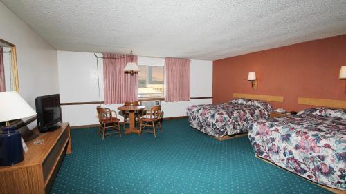 a hotel room with two beds and a table at Winners Inn Casino in Winnemucca