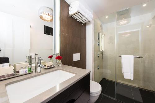 a bathroom with a sink and a toilet and a shower at Camden Harbour Inn a member of Small Luxury Hotels in Camden