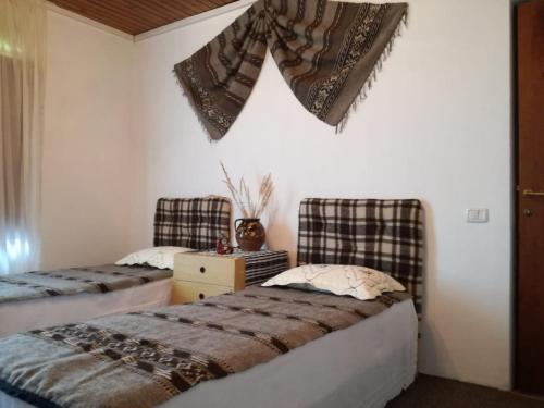 two beds in a room with blankets on the wall at Pensiunea La Poarta Bucovinei in Suceava