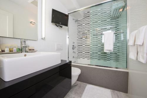 a bathroom with a sink and a toilet and a shower at Relais Chateaux Camden Harbour Inn in Camden